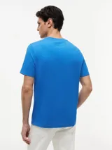 Remera de manga corta y cuello redondo de Tommy Hilfiger, confeccionada en puro algodón de color azul. Presenta un estampado con el logo de la marca y la inscripción "American Classics" en el pecho.