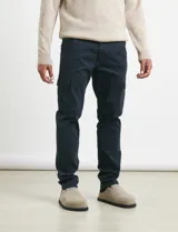 Pantalón cargo de algodón sarga con elastano, color verde militar. Presenta bolsillos laterales con fuelle, bolsillos traseros con tapa y botón, y costuras reforzadas en las rodillas.