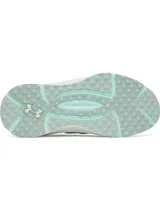 Championes Under Armour modelo UA W Phantom X, de color blanco con detalles en verde menta. Presentan parte superior de tejido transpirable, estructura de TPU translúcido en el mediopié con el logo de la marca, entresuela acolchada y suela de goma con tacos para tracción.