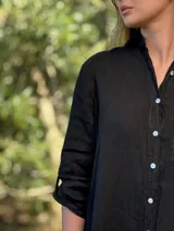 Vestido camisero color beige claro, de lino 100% natural, con botones de nácar, bolsillo delantero y mangas 3/4 con botón para recogerlas. Diseño asimétrico, más largo en la parte trasera.