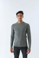 Sweater gris de punto con cuello redondo y mangas largas. Tiene un logo bordado en el pecho.