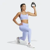 Top deportivo Adidas de soporte ligero, color lila claro, con tiras delgadas en la espalda y logo pequeño en el frente.