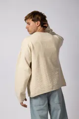 Sweater de punto liviano color negro con textura marcada, diseño de cuello redondo y calce holgado.