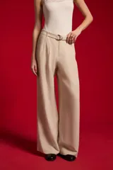 Pantalón ancho de lyocell color beige con pinzas en la parte delantera, tiro alto y un cinturón delgado con hebilla redonda metálica.