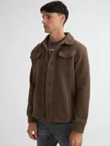 Camisaco color beige confeccionado en sherpa (corderito) con cartera de botones de pasta a tono y bolsillos con solapa en pecho.