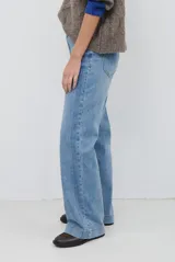 Pantalón jean de tiro alto y corte wide leg, en color azul medio con lavado clásico, bolsillos delanteros y traseros, y cierre frontal con botón y cremallera.