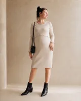 Vestido midi de punto acanalado en color beige, con cuello redondo, mangas largas y aberturas laterales en el ruedo. Presenta un diseño recto con apertura frontal oculta para lactancia.