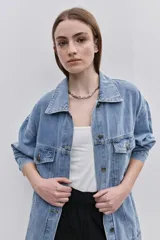 Campera de jean de silueta amplia, con cuello clásico y cierre frontal con botones. Diseño con bolsillos con solapa en el frente y bolsillos laterales, hombros caídos y terminaciones pespunteadas.