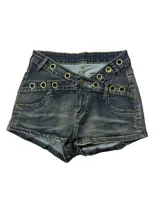 Short de denim tiro bajo con diseño cruzado en la cintura, efecto desgastado y detalles de ojalillos metálicos dorados.