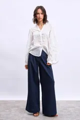 Camisa blanca de mangas largas con apliques de encaje en los puños y en los hombros.