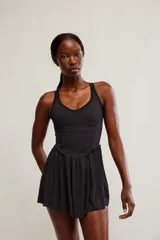 Vestido corto deportivo negro con efecto smock en el torso, tirantes finos blancos y falda de vuelo suave.