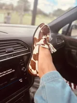 Alpargatas tipo mocasín de gamuza color amarillo mostaza, con detalle de flecos en la capellada.