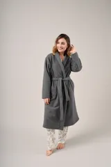 Bata de polar gris con textura labrada, diseño cruzado con lazo ajustable en la cintura, bolsillos laterales y mangas largas.
