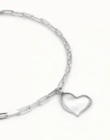 Collar de cadena de eslabones medianos con dije de corazón central, acabado en tono plateado.