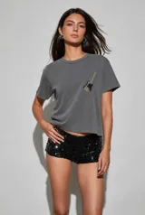 Remera gris oscuro de corte holgado, con cuello redondo, mangas cortas y detalle de aplique bordado con diseño de guitarra en el pecho.