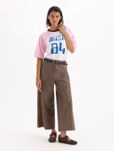 Pantalon de cuero ovino marron, de tiro alto, silueta wide-leg con recortes horizontales a la altura de la rodilla y bolsillos aplicados en la espalda. Incluye un cinturon de cuero al tono.