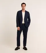 Saco de traje masculino confeccionado en mezcla de lino y viscosa, con cierre frontal de dos botones, bolsillos laterales con solapa y medio forro interior.