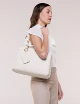 Cartera de hombro estructurada de eco cuero color beige, con diseño tripartito que incluye un compartimento central con cierre metálico y dos compartimentos laterales con broche magnético. Cuenta con asas dobles con detalle de cadena metálica, aplique metálico del monograma y un tarjetero independiente desmontable.