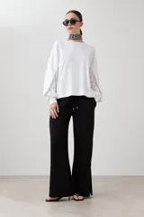 Sweatshirt blanco de manga larga con cuello redondo y puños elásticos.