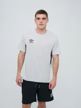 Remera deportiva de manga corta Umbro modelo Vant, de color gris claro con detalles en negro en los laterales y el logo de la marca bordado en el pecho.