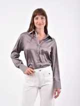 Camisa de manga larga color gris satinado, con cuello camisero y botones frontales.