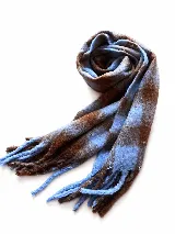 Bufanda de tejido suave con diseño a cuadros en tonos blanco, gris y negro, con flecos en los extremos.