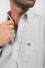 Camisa Oxford de corte clásico, confeccionada en 100% algodón con diseño de cuadros multicolor sobre fondo blanco. Presenta cuello camisero con botones, bolsillo frontal con logotipo bordado y cierre delantero de botonadura.