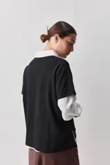Remera de manga corta negra de algodón, con silueta relajada, cuello redondo y tajos laterales.