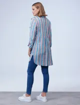 Camisola estampada a rayas verticales en tonos celeste, azul, naranja y marrón. Cuello con solapa, abertura central con botones y bolsillo aplicado en el pecho. Mangas largas regulables con presilla y botón. Laterales con bolsillos en costura. Marca Ruby Rd.