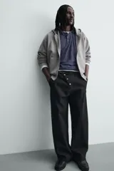 Pantalón wide fit de algodón con efecto lavado, corte recto y holgado. Presenta un cierre frontal cruzado con botones y un alamar metálico distintivo, además de bolsillos frontales y traseros de plastrón.