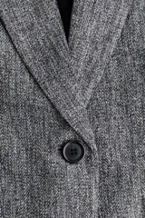 Blazer largo de corte recto con solapas de muesca, cierre frontal de un botón y bolsillos delanteros ribeteados. Presenta hombreras, pinzas en la cintura y mangas tres cuartos con diseño fruncido. Incluye forro interior.