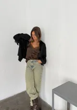 Campera marrón con cuello camisero, corte cuadrado, cierre frontal con botones y flecos en espalda y mangas.