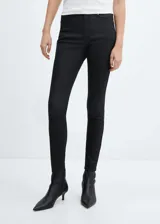 Pantalón tipo jeans de corte skinny y tiro alto, con acabado efecto encerado. Cuenta con diseño de cinco bolsillos, trabillas para cinturón y cierre frontal con cremallera y botón.
