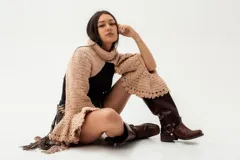 Bolero de punto artesanal en lana merino color marrón, con diseño de cuello alto y mangas amplias con terminaciones caladas.