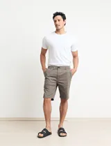 Bermuda de gabardina color verde medio, con cierre de botón y cremallera, bolsillos laterales y traseros.