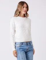 Buzo blanco de tejido calado con perlas bordadas, cuello a la base y manga larga, de la marca Nanette.