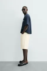 Camiseta de manga corta, cuello redondo y calce relajado, confeccionada en tejido con estructura waffle de color azul marino. Presenta estampados y bordados combinados a contraste en el delantero con texto en blanco.