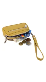 Monedero compacto de símil cuero color beige, con doble compartimento principal con cierre y un bolsillo frontal con cierre. Incluye una correa de mano lateral.