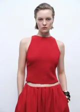 Top corto sin mangas de color rojo, con cuello redondo y diseño de espalda abierta con cierre de lazo. Cuenta con forro interior.