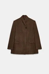 Blazer marrón de la colección Zara Woman, confeccionada en hilatura con 38% lana. Presenta cuello subido, manga larga con abertura y botones, bolsillos con solapa en el delantero y forro interior. Cierre frontal con un botón.