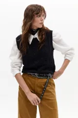 Cinturón de cuero con tachas metálicas circulares distribuidas a lo largo de toda la tira. Presenta una hebilla metálica rectangular y un diseño largo que permite dar una doble vuelta.