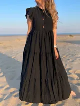 Vestido largo celeste de corte holgado, con cuello mao, mangas cortas y botones frontales.