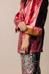 Blazer de cuero dorado metalizado, con bolsillos frontales aplicados, solapas clásicas y cierre con grandes botones de nácar.