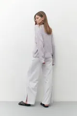 Cardigan lila de tejido de punto con escote en V y cierre con botones. Mangas largas y corte holgado.