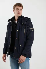 Campera de abrigo estilo parka, color verde militar, con capucha desmontable, cierre frontal con botones y múltiples bolsillos funcionales en pecho, cintura y manga.