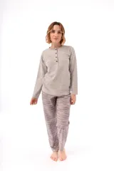 Pijama de dos piezas compuesto por una remera de manga larga con cuello redondo y cartera de botones, y un pantalón largo de corte recto. Ambas prendas presentan un estampado geométrico sutil en tonos gris y azul.