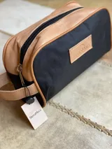 Neceser de lona verde con detalles en cuero color beige y etiqueta con logo de la marca Sierra Mora.