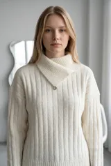 Sweater de punto gris con textura acanalada, cuello alto con solapa cruzada y detalle de botón metálico.