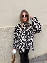 Buzo de peluche con estampado animal print de leopardo, de corte oversize, cuello redondo y mangas largas.