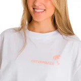 Remera blanca de corte oversize con mangas cortas y cuello redondo. Estampado pequeño en el frente con el logo de Caterpillar y una palmera en color naranja.